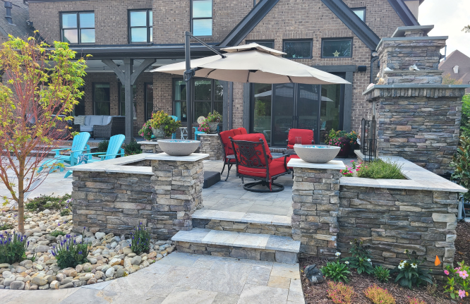 A retaining wall with stone stairs and a fireplace.