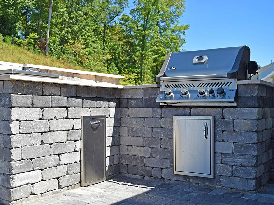 A metal outdoor kitchen built into a stone countertop