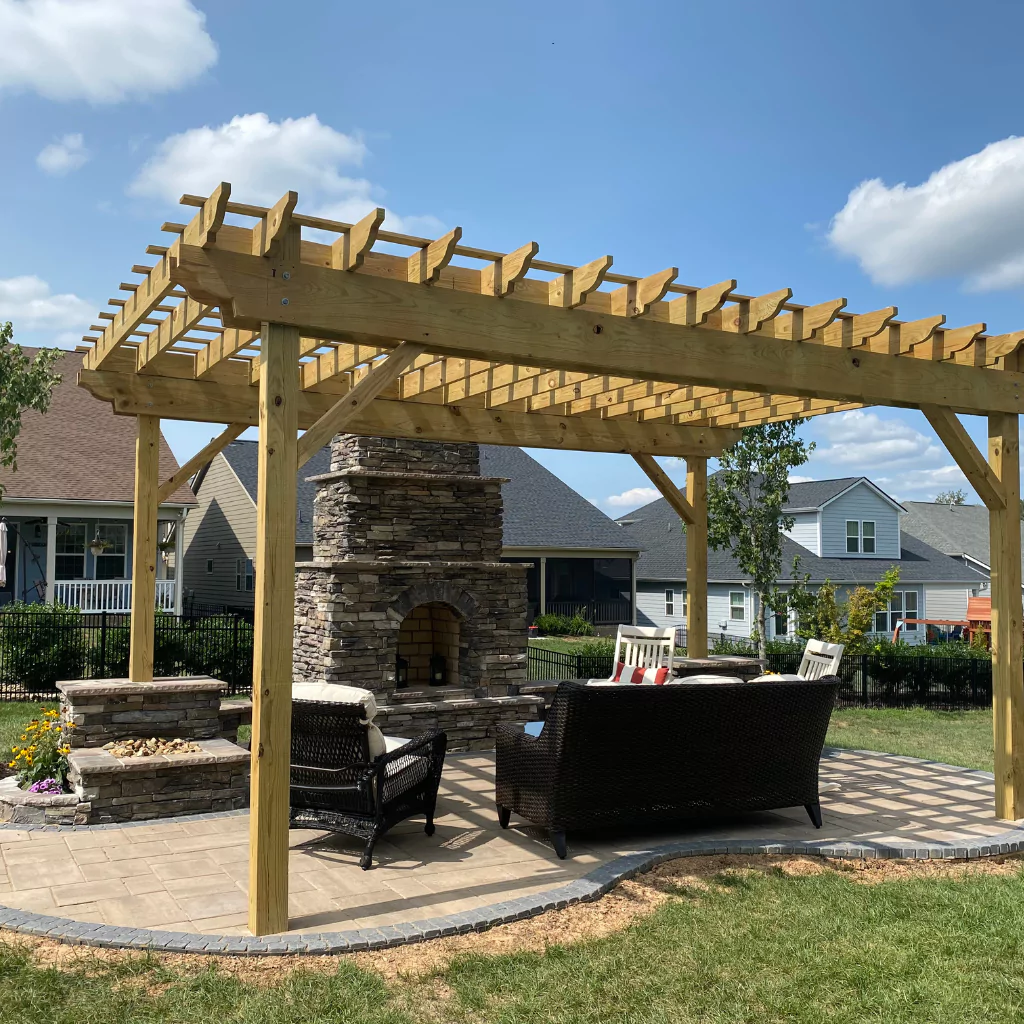 An outdoor fireplace accompanied by a pergola and outdoor furniture.