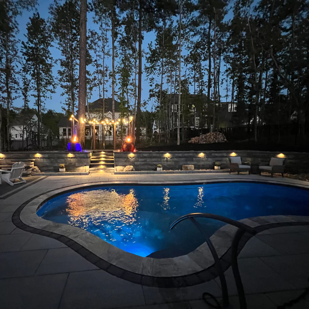 A beautiful swimming pool in a patio. It is at night and the illumination of the pool creates a spectacular effect.