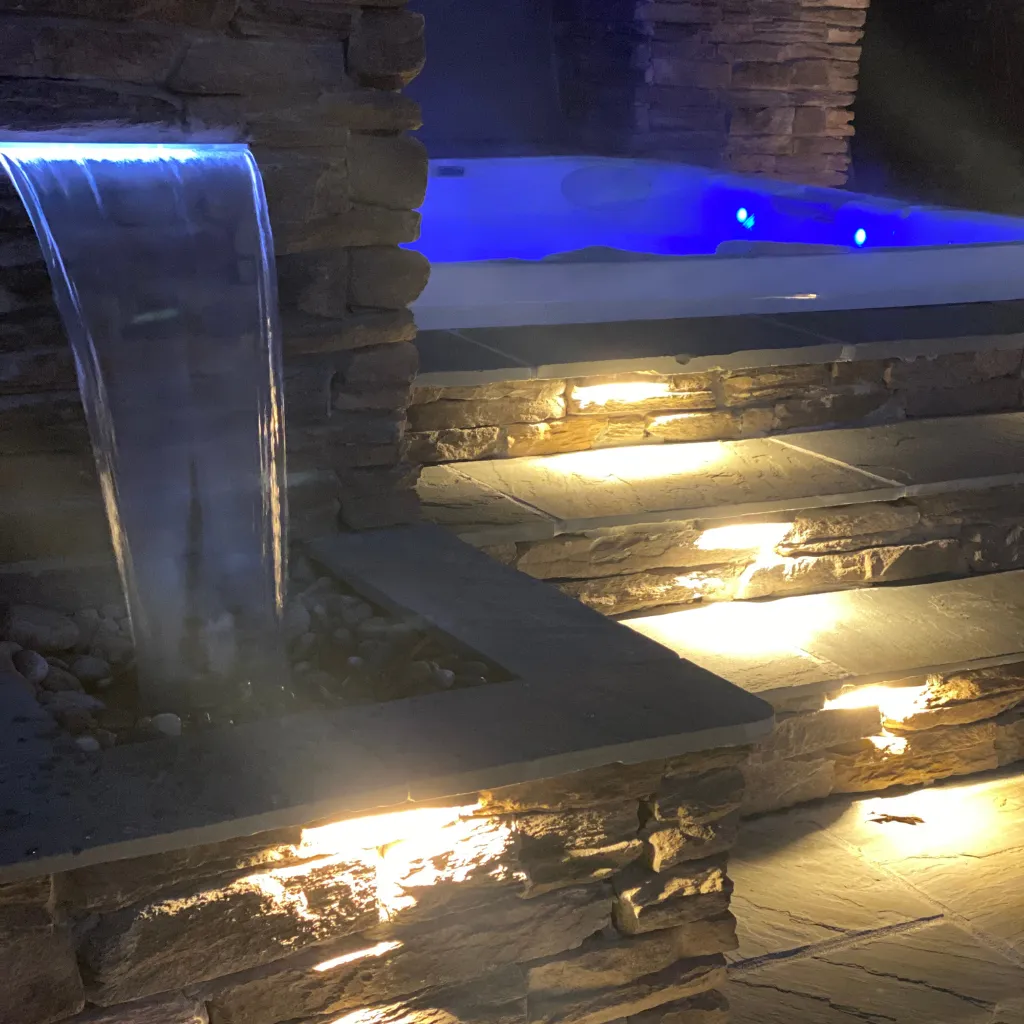 A fountain along with a hot tub. Both are illuminated with led lamps that change colors.