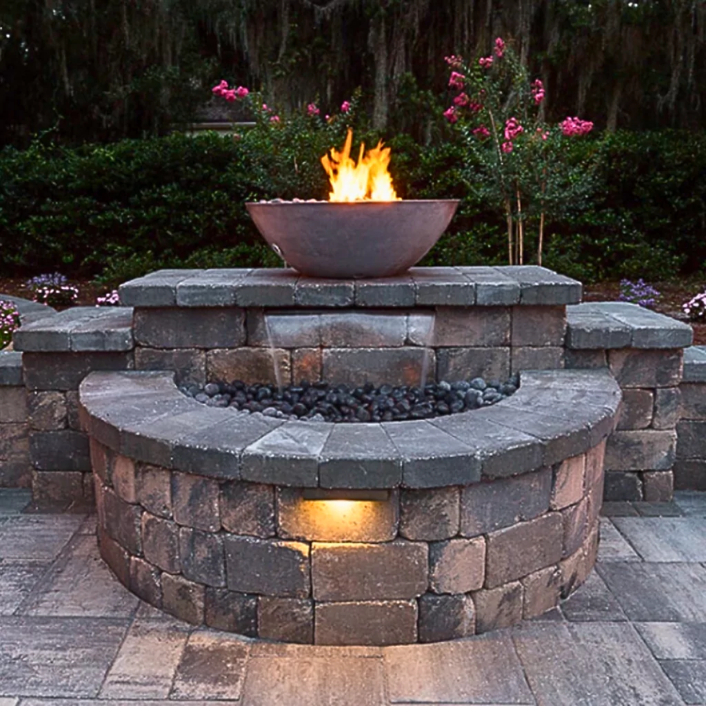 A beautiful stone fountain built in a courtyard. It has fire features that complement the design and makes a unique blend of the elements stone, water and fire.
