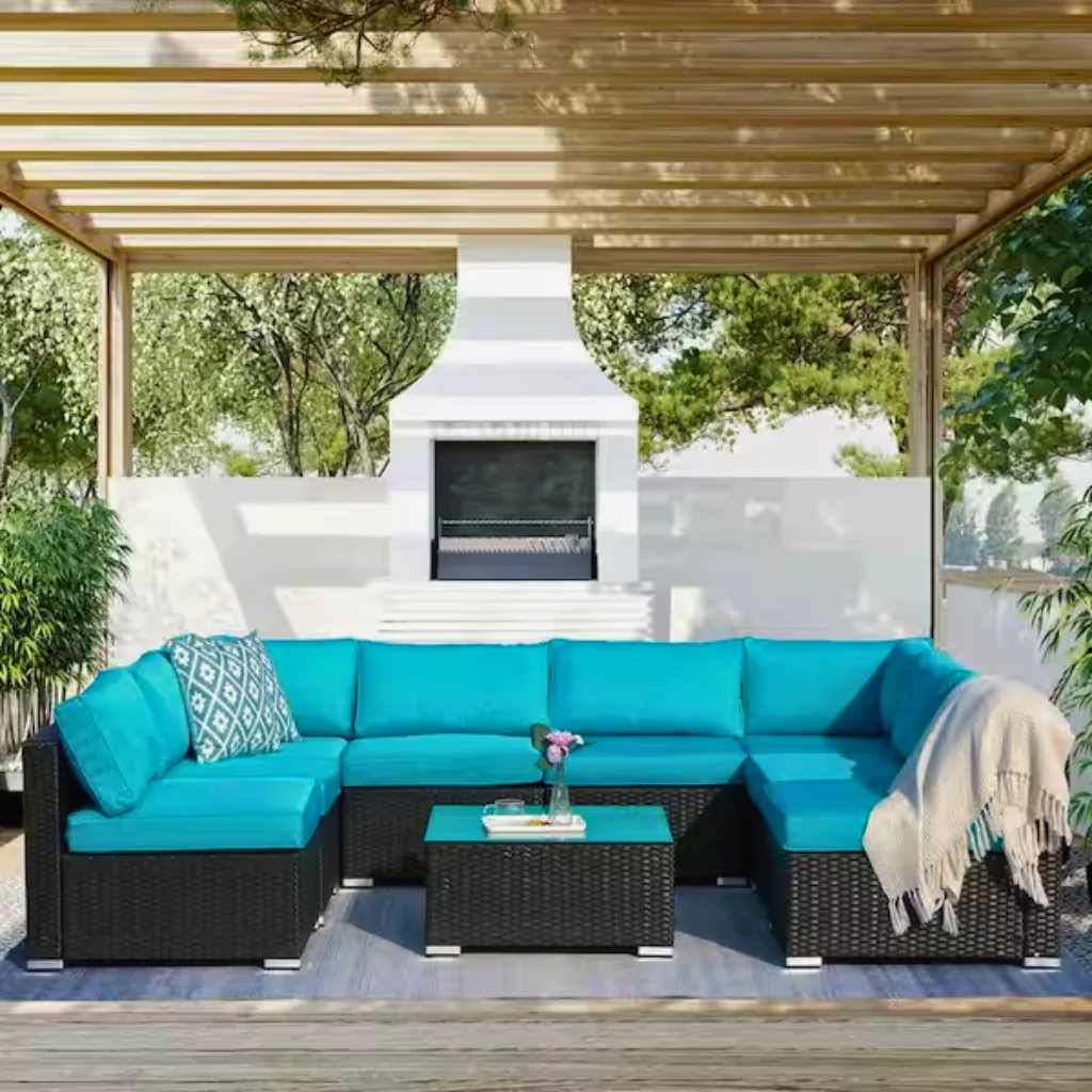 A sofa with cushions and blankets under a pergola
