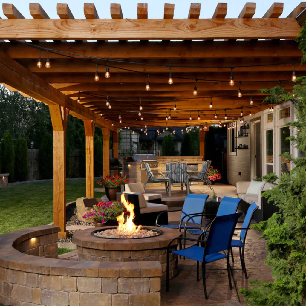 A charming pergola decorated with string lights. Also, there's a Fire Pit above the Pergola and some chaars around it