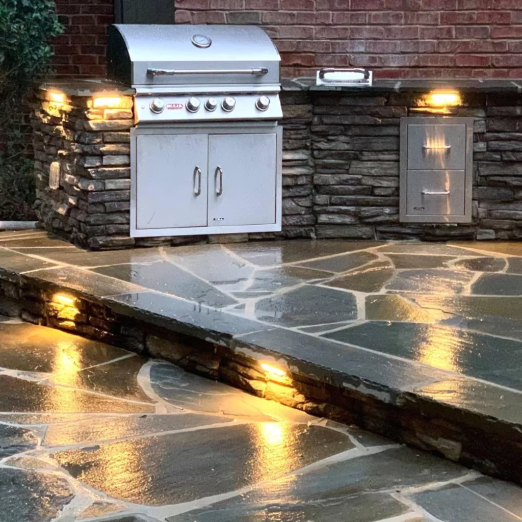 A stone outdoor kitchen with a precious stone floor.