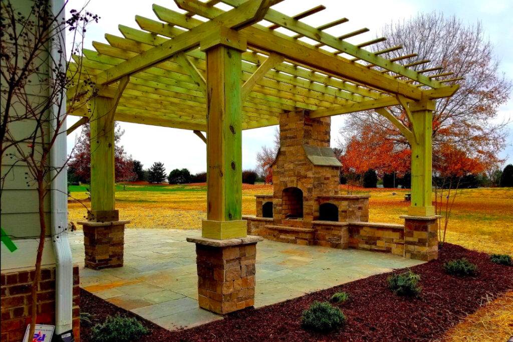 A fireplace under an elegant wooden pergola in a patio.