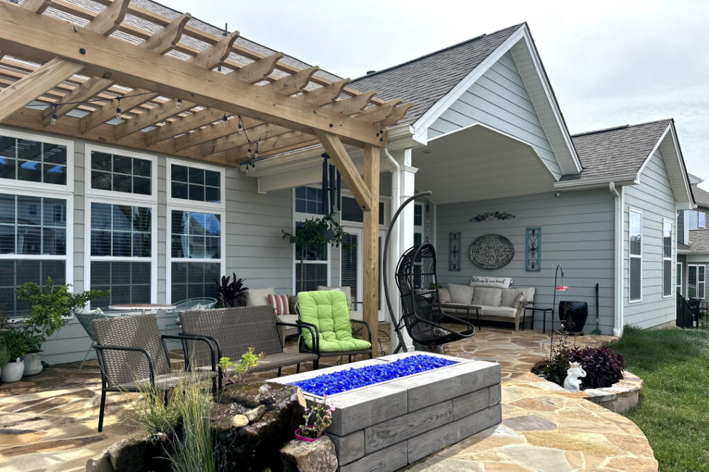A patio with an outdoor kitchen. This kitchen is covered with a pergola.