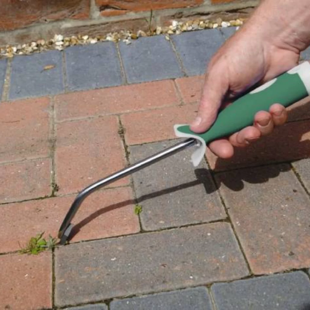 A person cleaning a paver with specialized tools