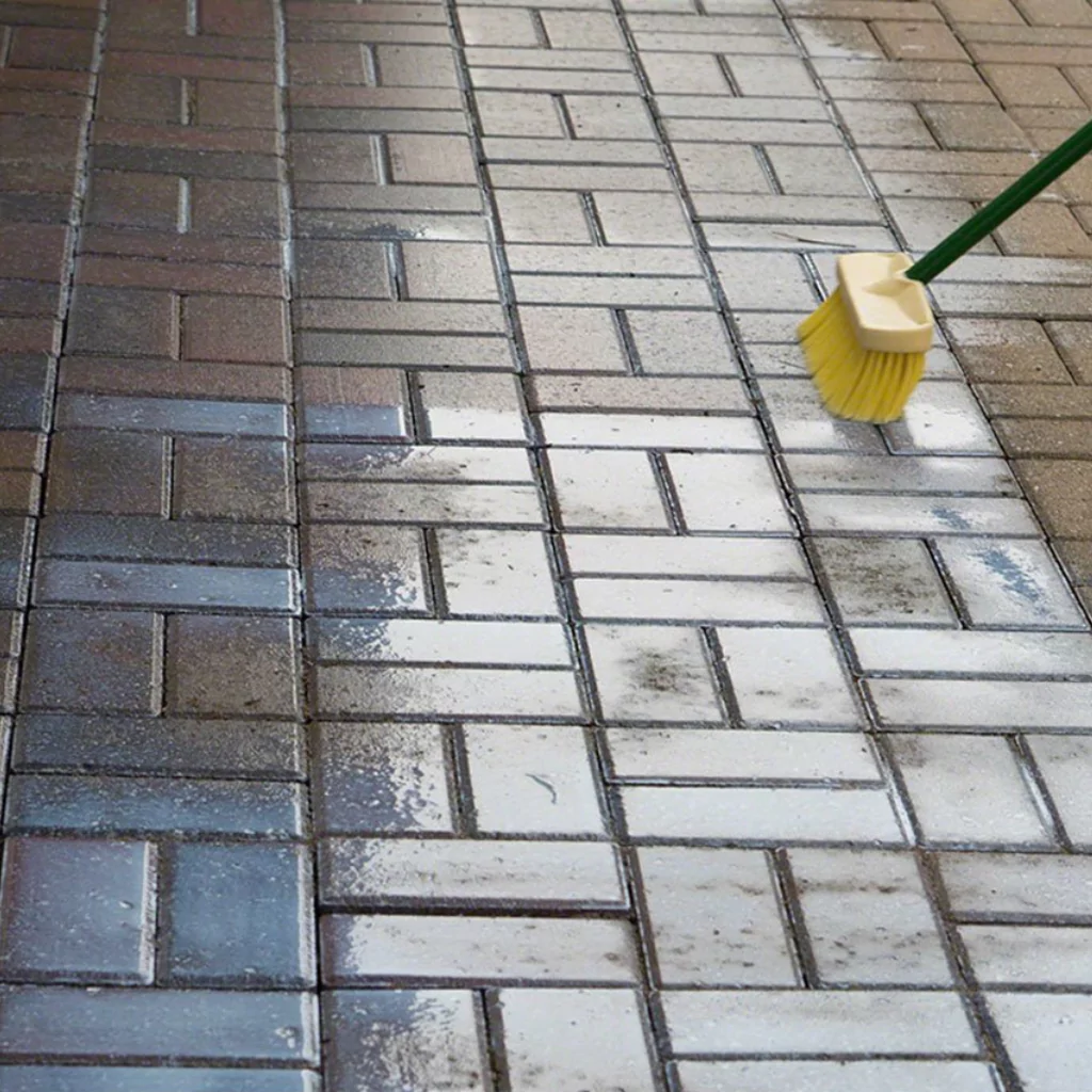 A person applying a paver sealer