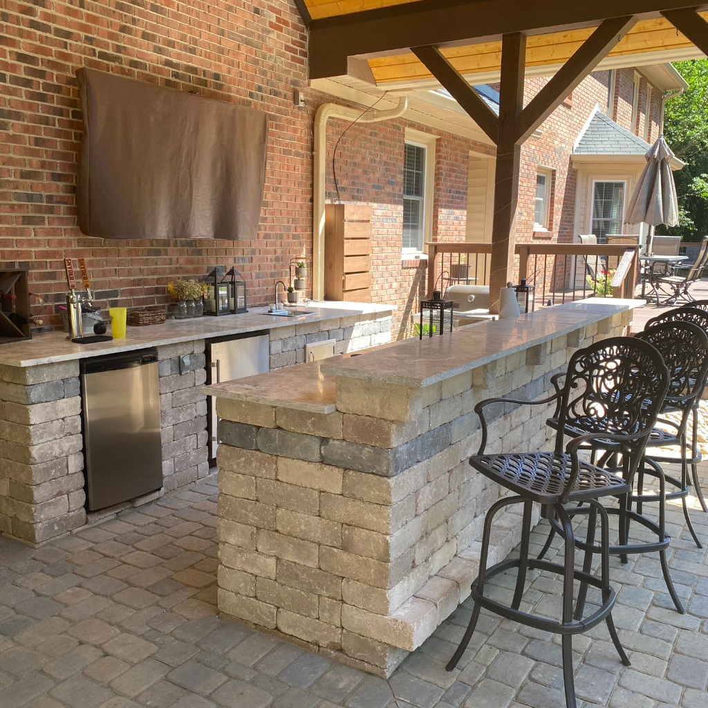 An outdoor kitchen with bar and dinning area