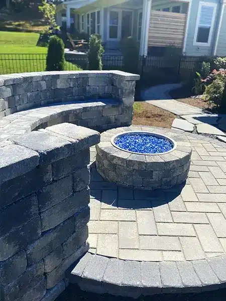 A beautiful stone fire pit along with a sitting wall. The perfect combination to create beautiful memories in your backyard.