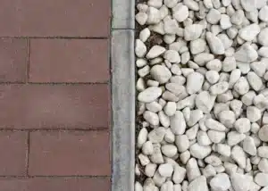 Un South Carolinas expertly combines contrasting hardscape materials like traditional pavers and smooth pebbles using defined edging for visual interest.