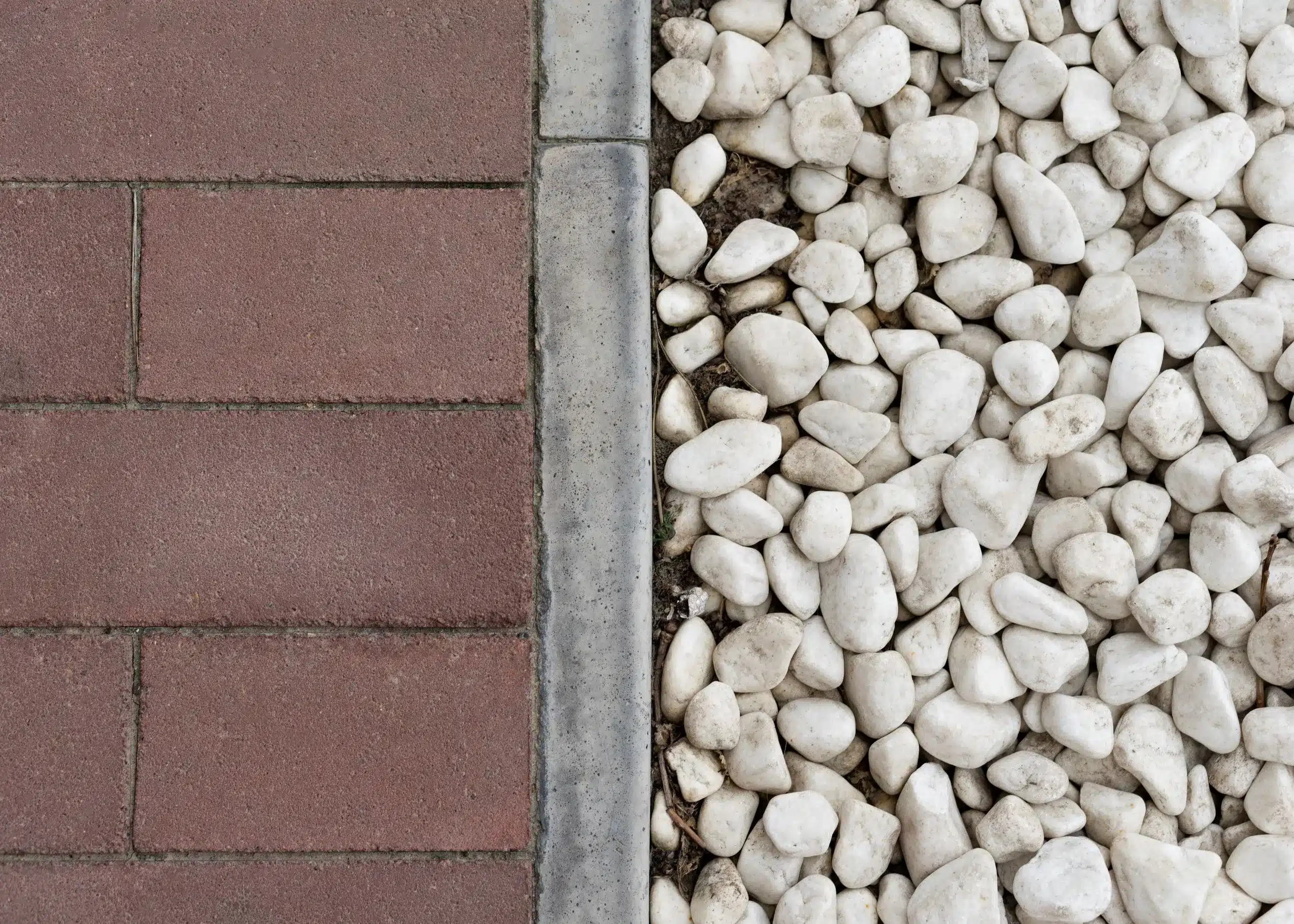 Un South Carolinas expertly combines contrasting hardscape materials like traditional pavers and smooth pebbles using defined edging for visual interest.