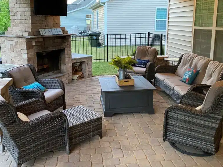 Un South Carolinas custom outdoor fireplace becomes the focal point of this covered patio, complementing the hardscaping and custom outdoor lighting.