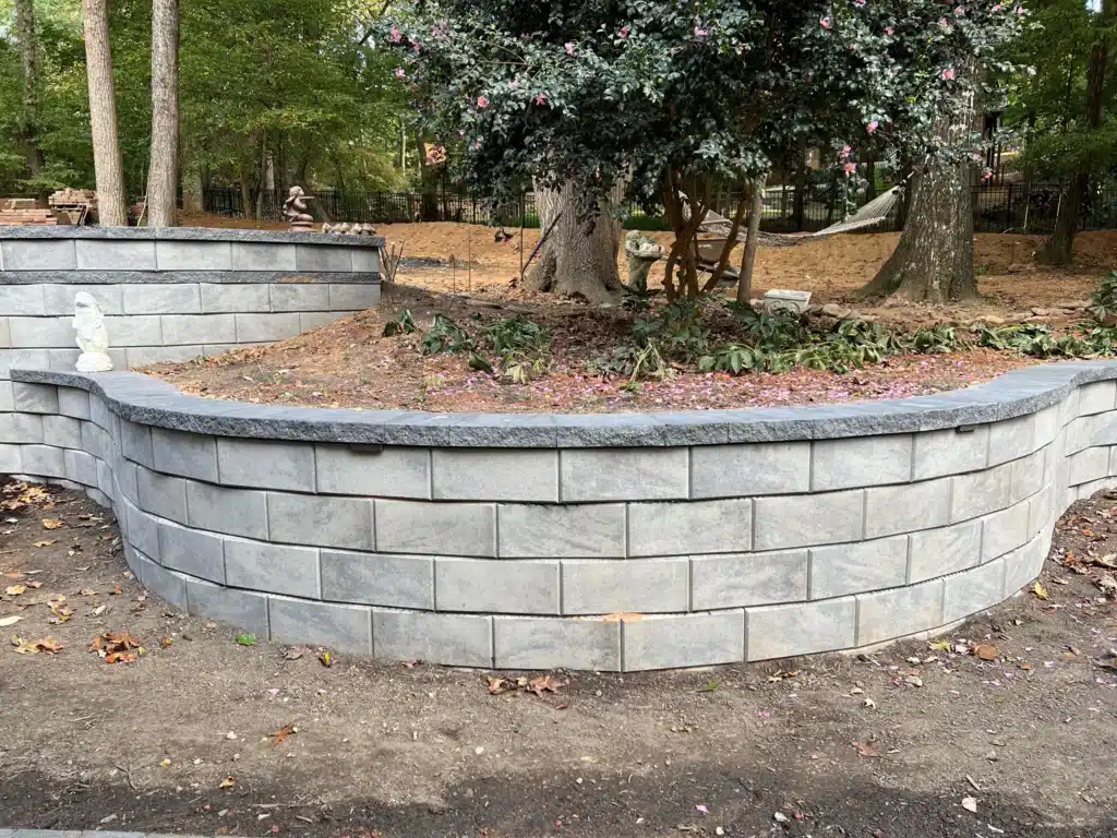 Retaining Walls and Runoff: Preventing Water Damage During Fall Rains in Raleigh 3 Expertly constructed hardscaping solution: Tiered segmental block retaining walls by SunSouth Carolinas define planting areas and add dimension to landscape design.