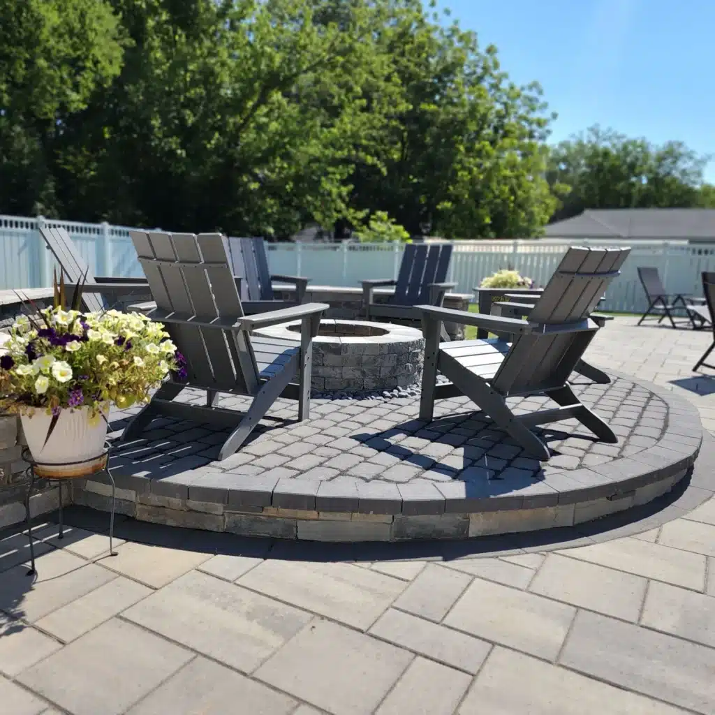 Romantic Outdoor Spaces: Fire Features Designed for Cozy Winter Nights 5 SunSouth Carolinas custom stone fire pit built into a circular paver hardscaping patio, edged perfectly with a matching masonry block retaining wall.