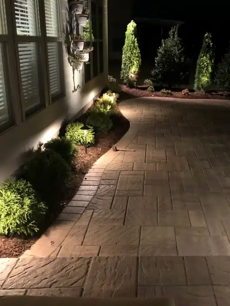 Holiday-Proofing Your Driveway and Paths: Anti-Slip and Maintenance Tips 5 Custom outdoor lighting service by SunSouth Carolinas highlights stamped concrete hardscaping walkway and border landscaping for safe, inviting nighttime entry.