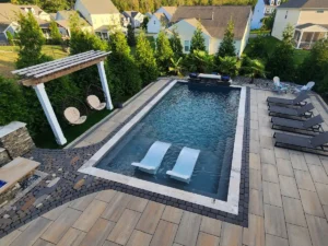 A stunning pool installation with clean lines and contemporary hardscaping, including a paver patio and a modern pergola, showcasing the expertise of SunSouth Carolinas in Raleigh.
