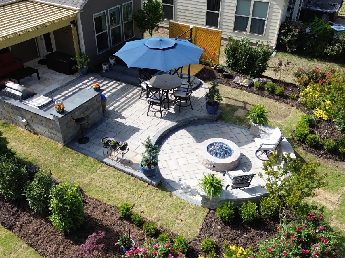 How Outdoor Renovations Fit Into Your 2026 Home Goals 1 A cohesive outdoor living space in Raleigh, featuring our expert paver patio, stone fire pit, retaining seat wall, and outdoor kitchen installation services.