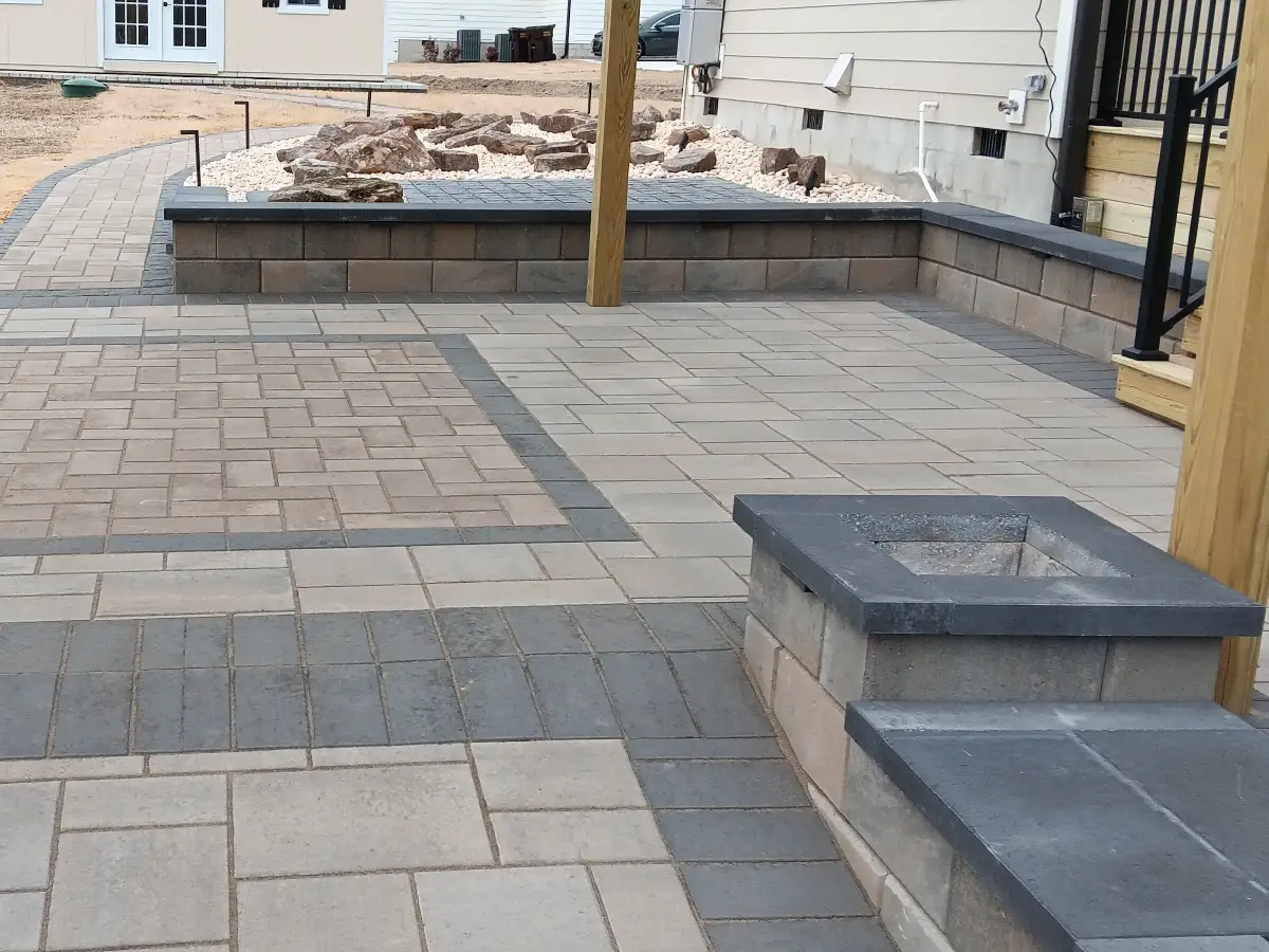 Retaining Walls and Runoff: Preventing Water Damage During Fall Rains in Raleigh 1 A multi-functional outdoor living space showcasing our services: paver patios, stone fire pits, retaining walls, and landscape lighting installation in Raleigh.