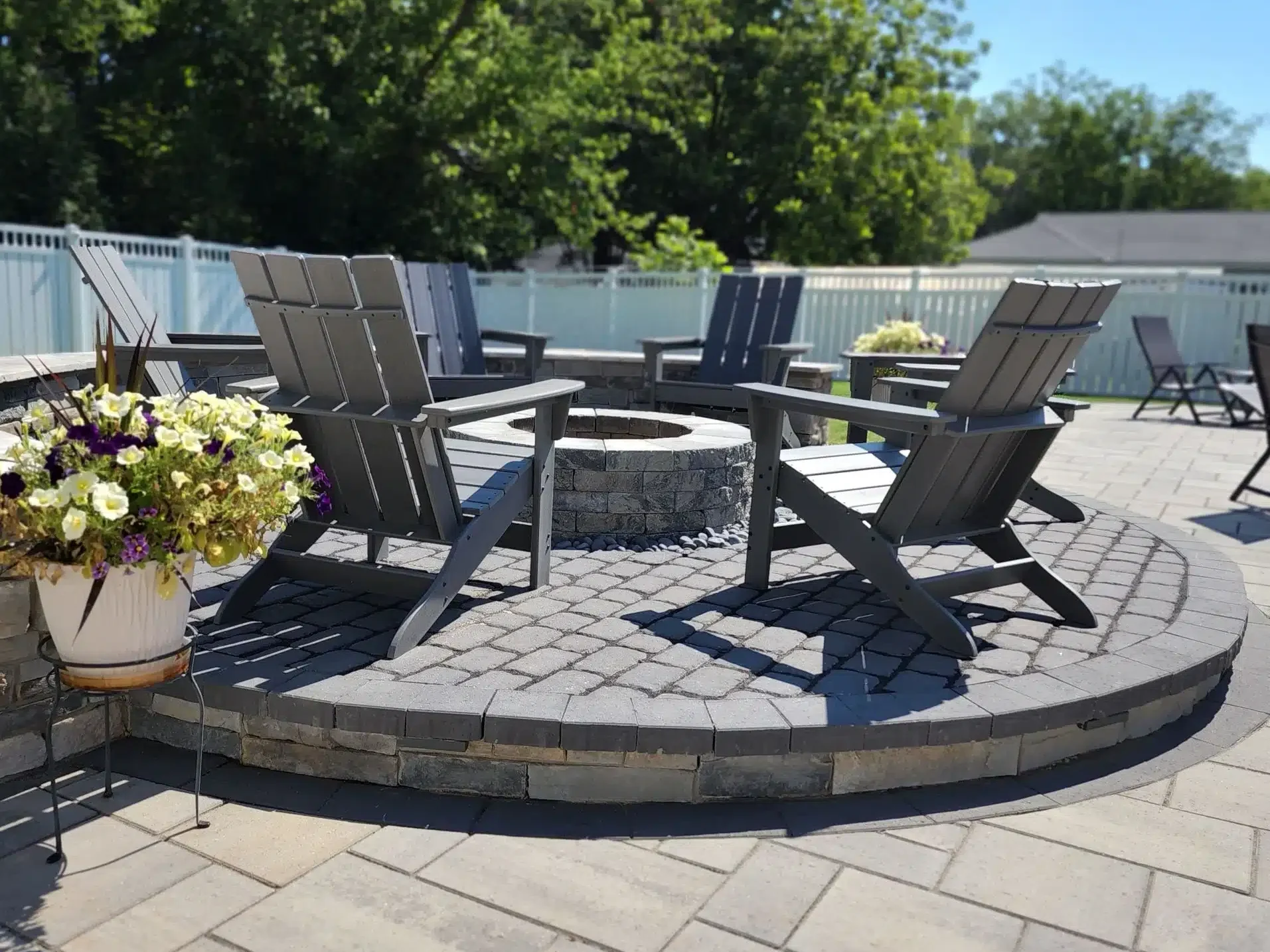 Hardscaping on a Budget: Affordable Upgrades Before Year-End 4 SunSouth Carolinas custom stone fire pit built into a circular paver hardscaping patio, edged perfectly with a matching masonry block retaining wall.